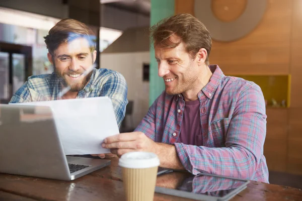 Два бизнесмена, работающие на ноутбуке — стоковое фото