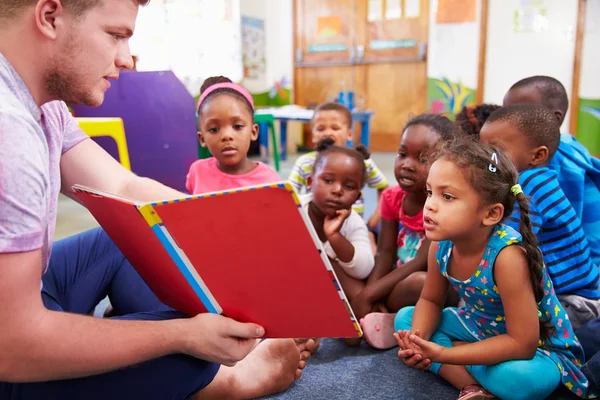 Vrijwilliger leraar lezen aan klasse — Stockfoto