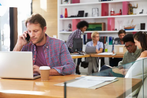 Affärsman på Laptop med mobiltelefon — Stockfoto