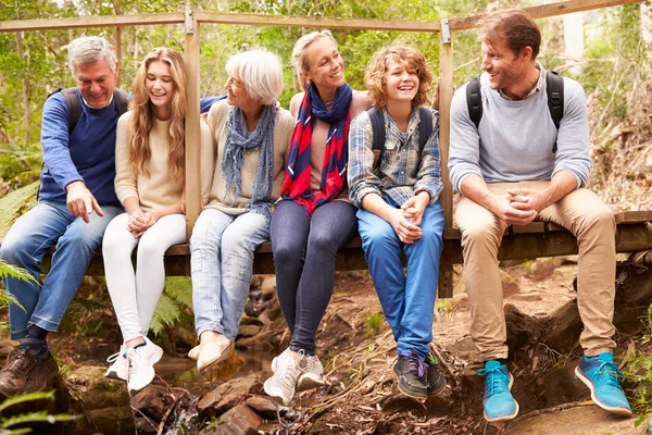 Family group sitting on bridge — Stock Photo, Image