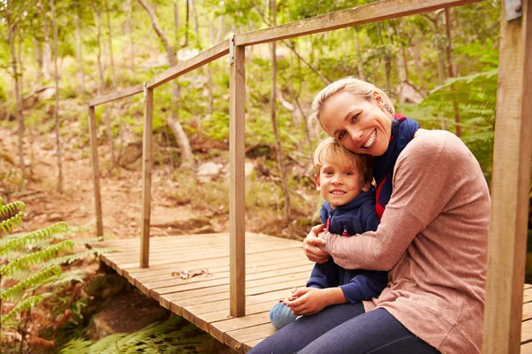 Moeder en jonge zoon omhelzen op een brug — Stockfoto