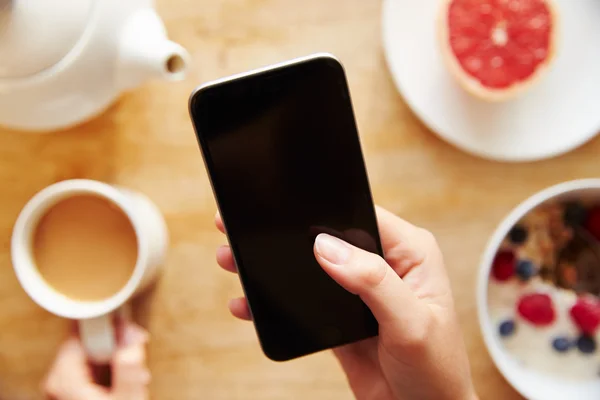 Persona en el desayuno mirando el teléfono móvil —  Fotos de Stock