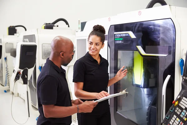 Aprendiz trabalhando com engenheiro em máquinas CNC — Fotografia de Stock