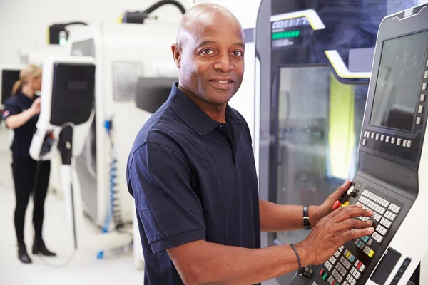 Engenheiro masculino operando máquinas CNC na fábrica — Fotografia de Stock