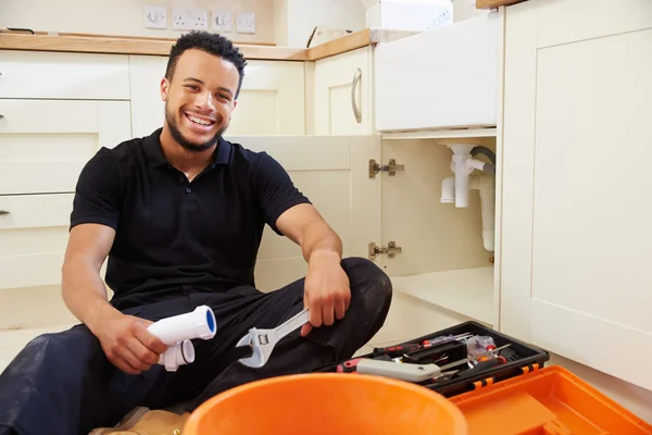 Encanador sentado em uma cozinha — Fotografia de Stock