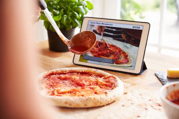 Siguiendo la receta de pizza en la tableta digital —  Fotos de Stock