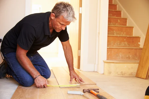 Homem que estabelece piso painel de madeira — Fotografia de Stock