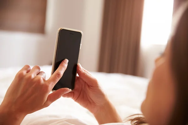 Femme utilisant un téléphone portable au lit — Photo