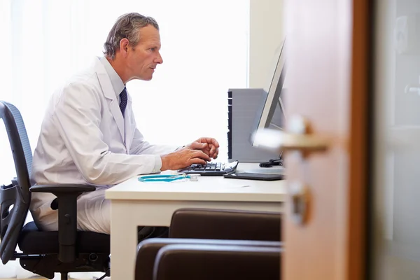 Médico trabajando en la computadora en la oficina — Foto de Stock