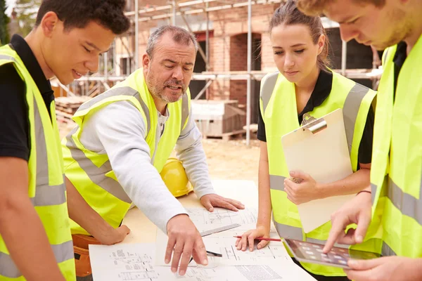 Bouwer bespreken van werken met leerlingen — Stockfoto