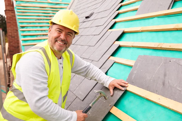 Obrero de la construcción colocación de baldosas de pizarra — Foto de Stock