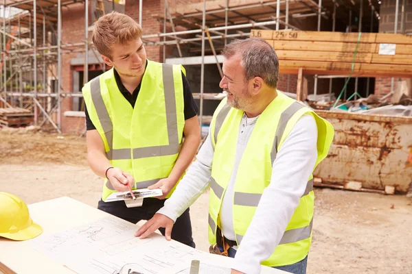 Bauarbeiter bespricht Arbeit mit Lehrling — Stockfoto