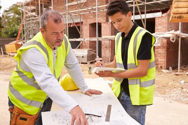 Builder diskuterar arbetet med lärling — Stockfoto