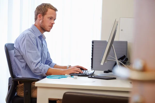 Médecin travaillant à l'ordinateur au bureau — Photo