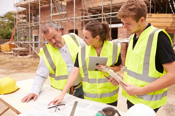 Bauunternehmer diskutiert Arbeit mit Lehrlingen — Stockfoto