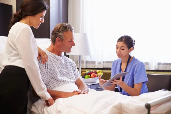 Krankenschwester im Gespräch mit männlichen Patienten und Ehefrau — Stockfoto