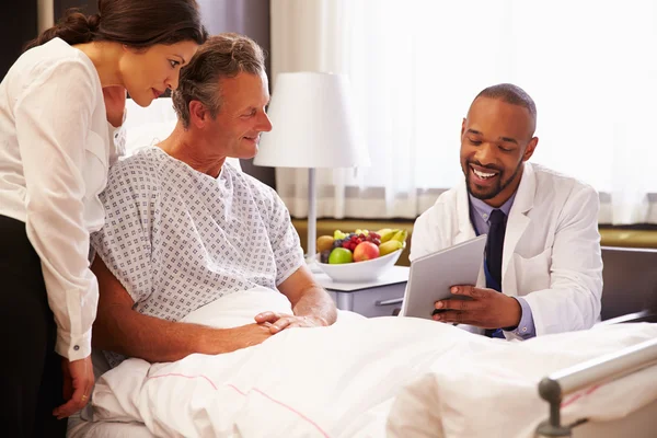 Doutor conversando com paciente e esposa na cama — Fotografia de Stock