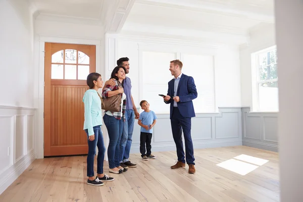 Realtor mostrando família em casa — Fotografia de Stock