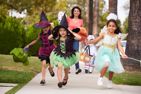 Parent prenant des enfants traitant à Halloween — Photo