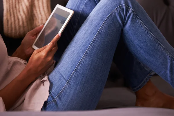 Женщина расслабляется дома с помощью цифрового планшета — стоковое фото