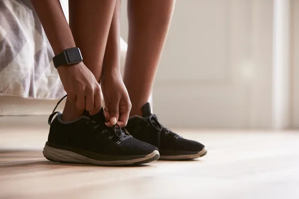 Mujer joven atando zapatos deportivos — Foto de Stock