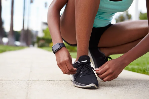 Mujer joven atando zapatos deportivos — Foto de Stock