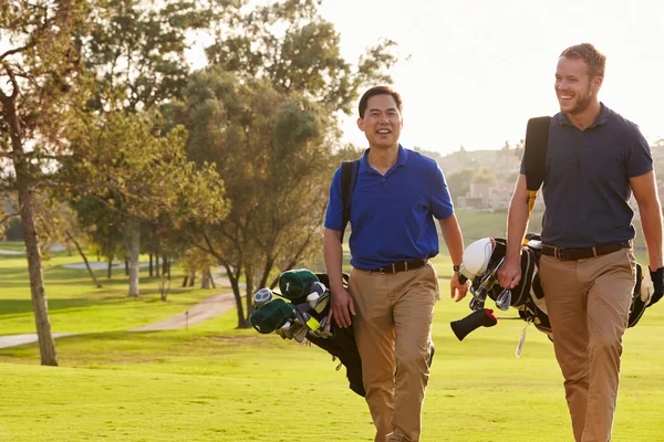 Golfistas masculinos llevando bolsas — Foto de Stock