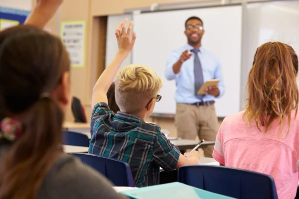 Niños levantando las manos para responder en clase — Foto de Stock