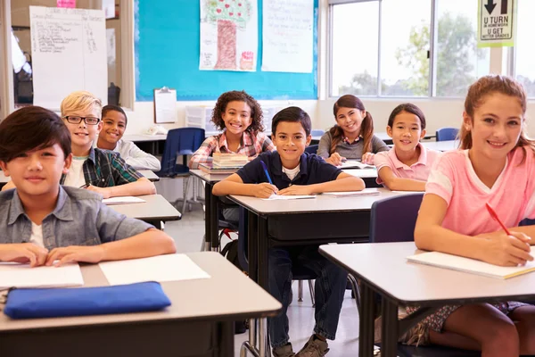 Grundskolan barnen sitter vid skrivbord — Stockfoto