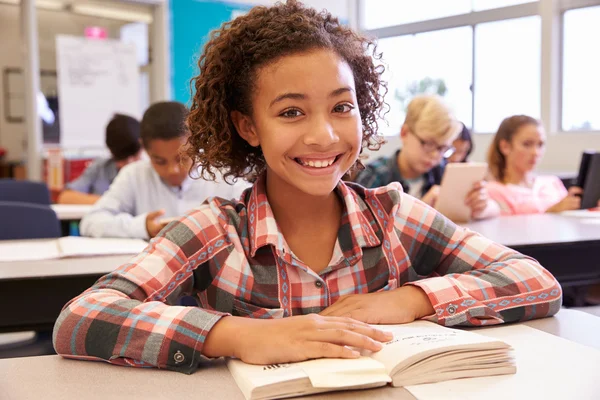 Skolflicka vid skrivbord i grundskolan — Stockfoto