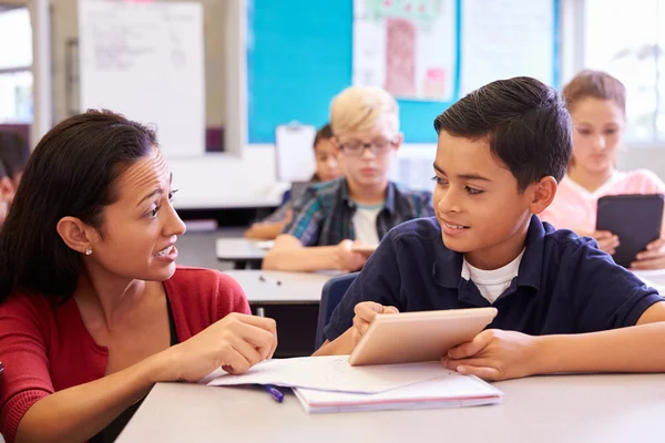 Teacher helping elementary school boy — Stock Photo, Image