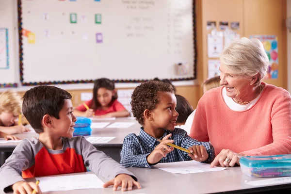Senior leraar zitten met kinderen in de klas — Stockfoto