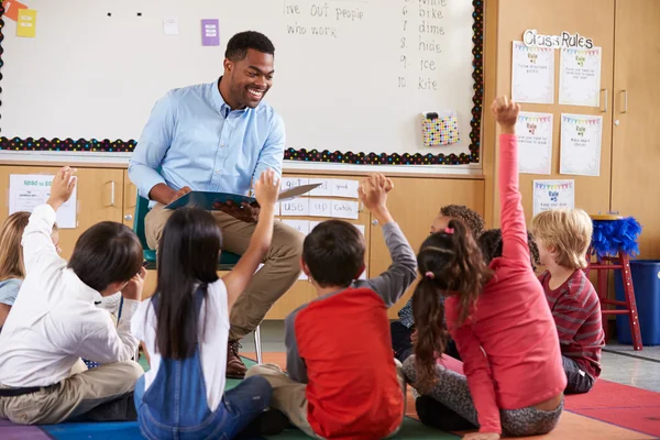 Barnen sitter runt lärare i ett klassrum — Stockfoto