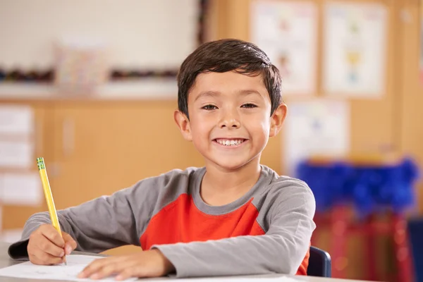 Boy at elementary school sitting in classroom — Stock Photo, Image