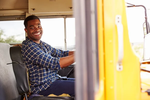 Conductor sonriente de autobús escolar sentado en el autobús — Foto de Stock