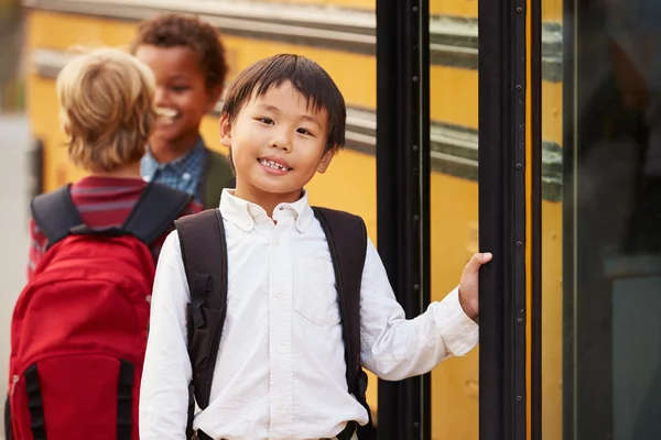 Мальчик перед школьным автобусом — стоковое фото