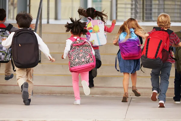 Miúdos da escola primária a correr para a escola — Fotografia de Stock