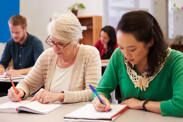 Mujeres compartiendo un escritorio en clase — Foto de Stock