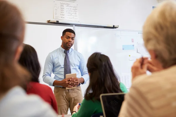 Mannelijke leraar luisteren naar studenten op klasse — Stockfoto