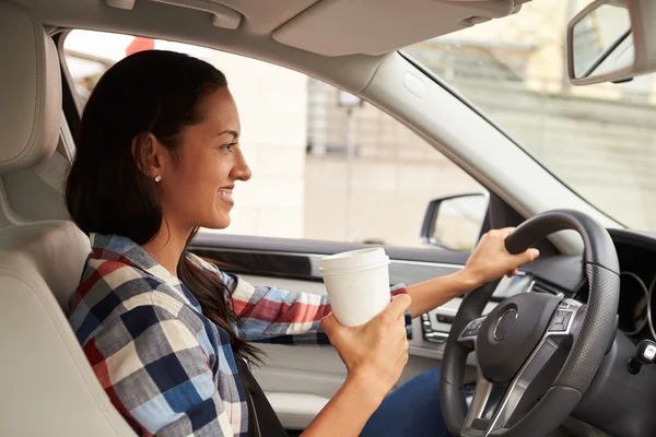 Conductora sosteniendo bebida para llevar — Foto de Stock