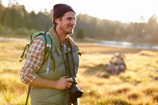 Muž, turistika s kamerou v krajině — Stock fotografie