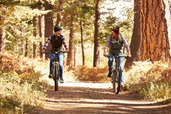 Pareja ciclismo de montaña a través del bosque —  Fotos de Stock