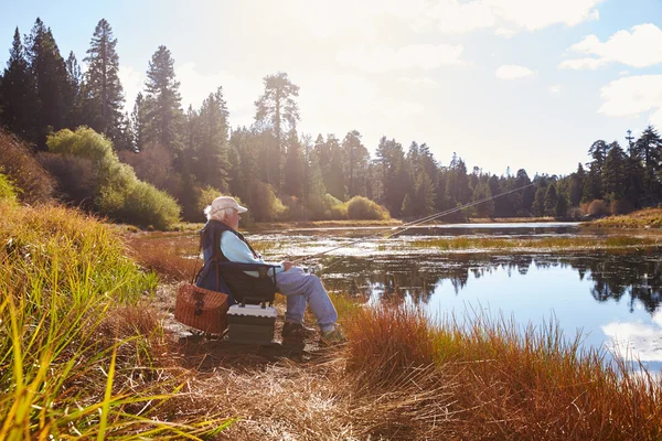 Senior man sits fishing — Stock Photo, Image