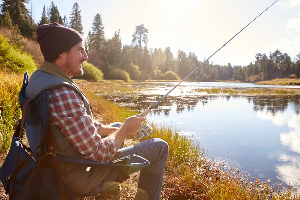 Hombre relajante y la pesca a orillas del lago — Foto de Stock