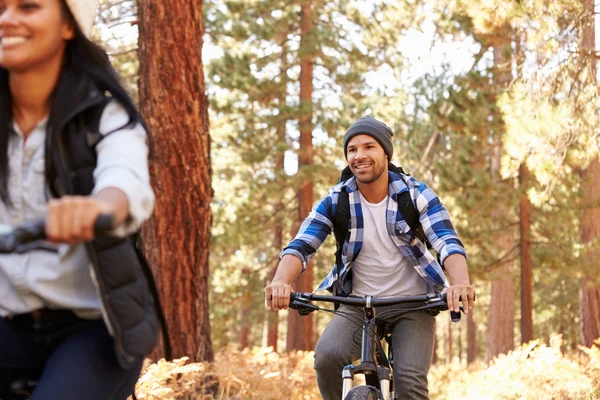 Pareja ciclismo a través de otoño Woodland —  Fotos de Stock