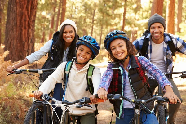 Famiglia in bicicletta attraverso la foresta caduta — Foto Stock