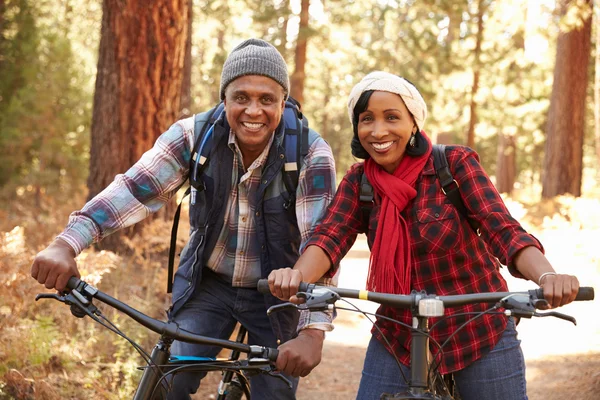 Äldre par cykling i skogsmark — Stockfoto