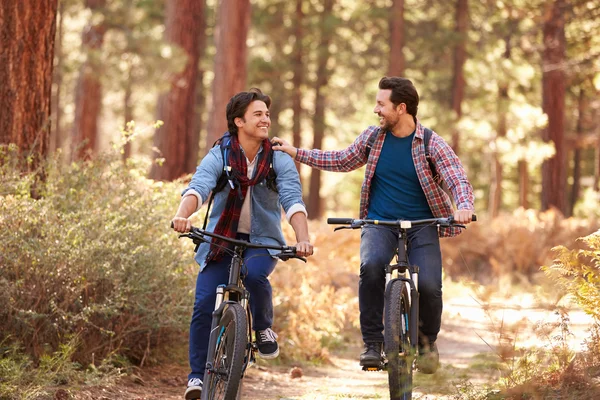 Casal masculino de bicicleta através da floresta — Fotografia de Stock