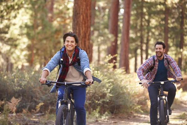 Couple masculin faisant du vélo à travers les bois — Photo