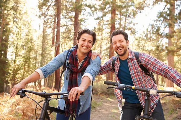 Manliga par cykling genom skogsmark — Stockfoto
